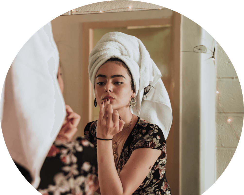 young-woman-applying-skincare-in-front-of-a-mirror