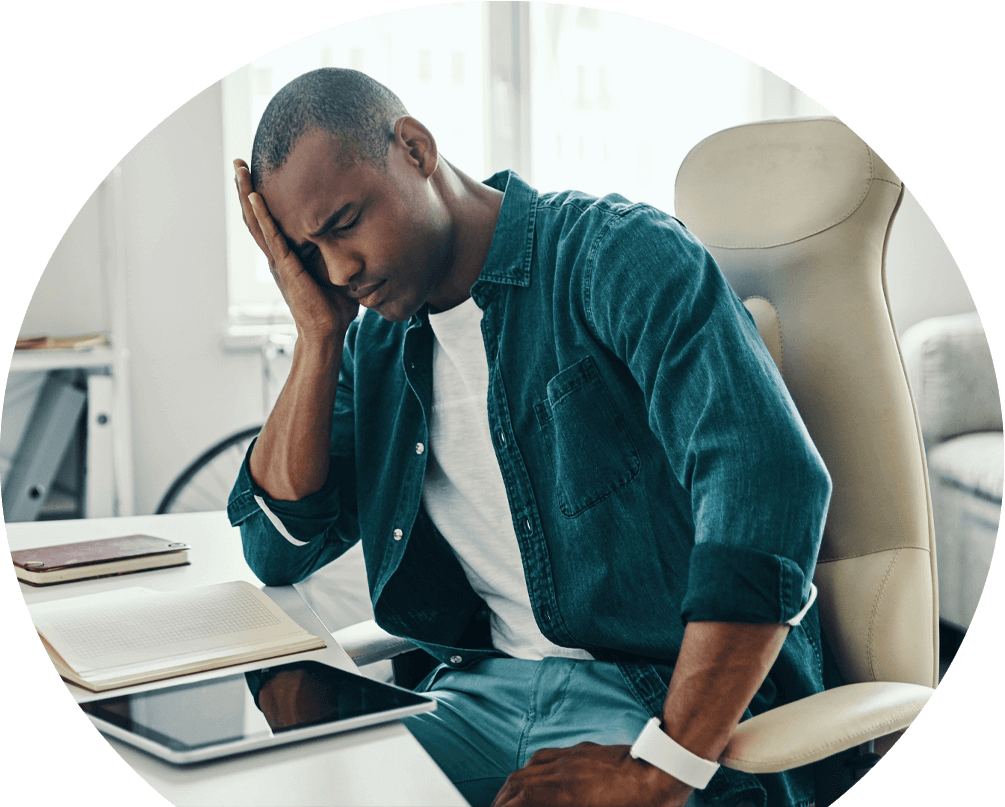 man-in-pain-at-desk-in-need-of-migraine-treatment