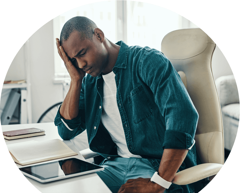 migraine-img man-in-pain-at-desk-in-need-of-migraine-treatment