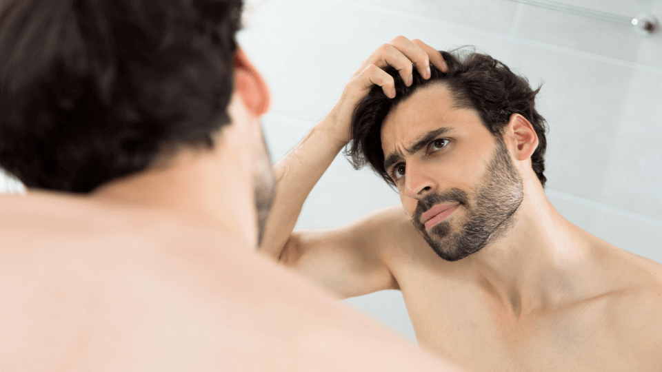 man-checking-receding-hairline-in-mirror