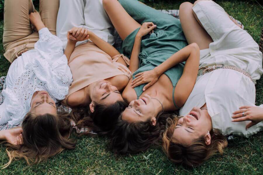 women-lying-on-the-grass-laughing