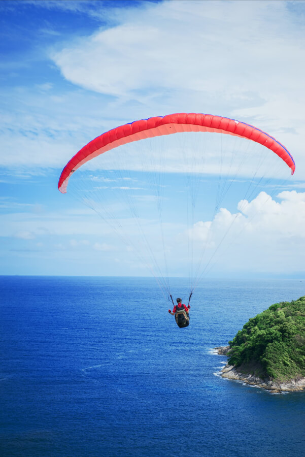 man-paragliding-off-the-coast-of-thailand